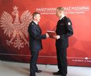zdjęcie dwóch strażaków przekazujących sobie dyplom