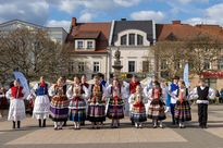 zdjęcie przedstawia dzieci na rynku w strojach ludowych