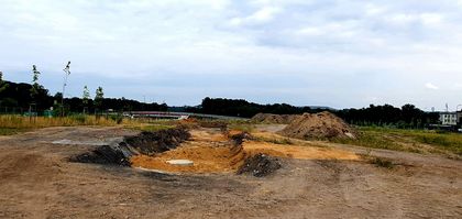 Roboty ziemne przy węźle drogowym - wykopy, łąka, niebo. 