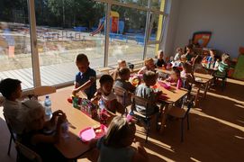 Grupa dzieci przedszkolnych bawiących się przy stolikach