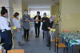 Kilka kobiet sprzatająych szkolną stołówkę