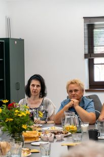 Zdjęcie przedstawia dwie siedzące kobiety.