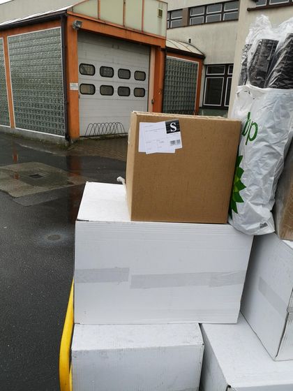 Paczki i kartony ustawione przed budynkiem