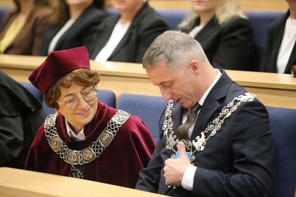 Mężczyzna i kobieta siedzą w auli i rozmawiają. 