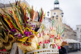 palmy wielkanocne na pierwszym planie zdjęciowym, na drugim ratusz miejski