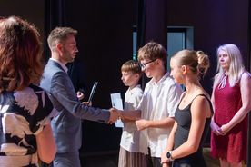 Osoby na scenie odbierające nagrody Prymus