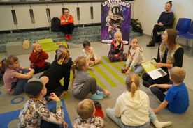 Dzieci siedzące na dywanie, pani z książką Juliusz