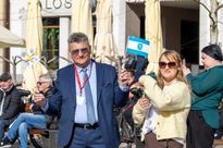 zdjęcie przedstawia ludzi machającymi flagami