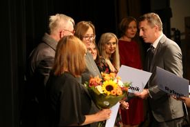 Gala Nagrody Literackiej Juliusz, na scenie nominowani do nagrody z bukietami kwiatów w rękach. Gratuluje im prezydent Rybnika Piotr Kuczera. 