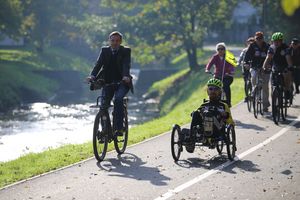 Asfaltowa droga rowerowa wzdłuż rzeki, grupa rowerzystów