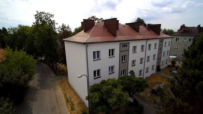 Wyremontowane bloki mieszkalne w jasnych barwach na tle nieba