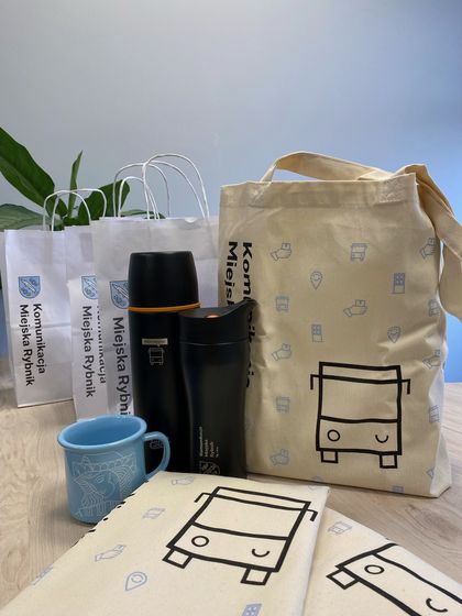 Materiały promocyjne spółki Komunikacja Miejska Sp. z o.o. - torba, kubek i termos. 