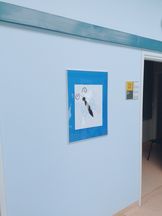 OsrodekJPII remont 6 Jasna ściana, na której przywieszona jest antyrama z rysunkiem motyla na błękitnym tle.