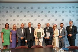 Zdjęcie przedstawia grupę osób na oficjalnym spotkaniu pozujących do zdjęcia. 