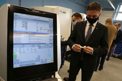 Mężczyzna stojący obok monitora w nowocześnie wyposażonej pracowni kształcenia zawodowego 