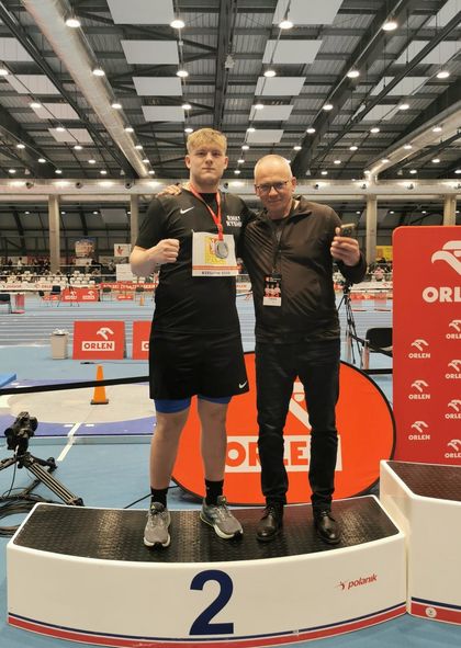 Mężczyźni stojący na podium na hali sportowej