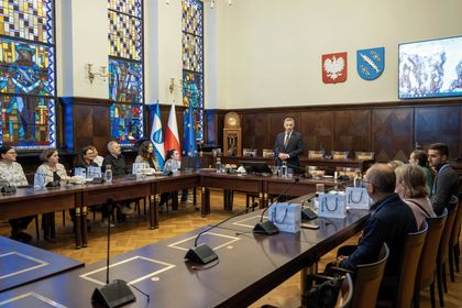 Grupa osób na sali sesyjnej podczas oficjalnego spotkania. 