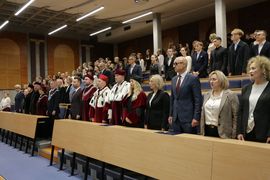 Grupa osób stojąca na auli. 