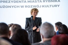 Kobieta przemawia do mikrofonu.