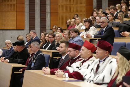 Grupa osób siedząca w auli. 