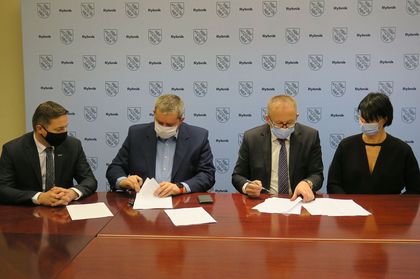 Podpisanie umowy z wykonawcą wielorodzinnego budynku mieszkaniowego przy ulicy Hallera. Przy stole przedstawiciele Rybnika z prezydentem miasta na czele oraz reprezentanci konsorcjum firm realizujących inwestycję 