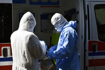 Wymazobus fot.K 5 Karetka pogotowia i medycy w kombinezonach ochronnych.