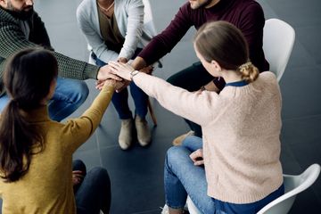 Grupa osób, która stoi w okręgu.
