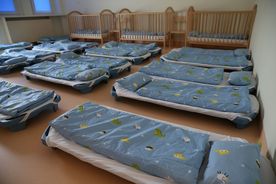 Wnętrze sali żłobkowej, na całej powierzchni rozstawione łóżka do spania 