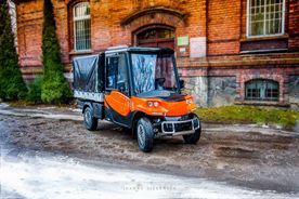 Pomarańczowy pojazd typu melex na tle rybnickiego szpitala psychiatrycznego