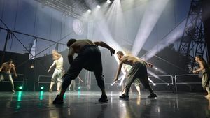 Spektakl na plenerowej scenie. Na scenie światła i tancerze