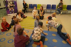 Dzieci siedzące na dywanie, pani z książką Juliusz