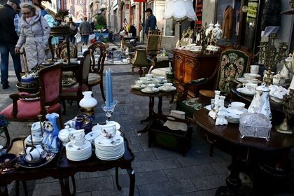 Uliczny jarmar staroci - stare meble, stoliki, krzesła, na nich drobne przedmioty
