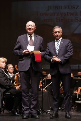 Mężczyźni stojący na scenie podczas wręczania nagród. 