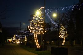 Świecące o zmierzchu świąteczne dekoracje miasta - choinka, karuzela, girlandy nad ulicą