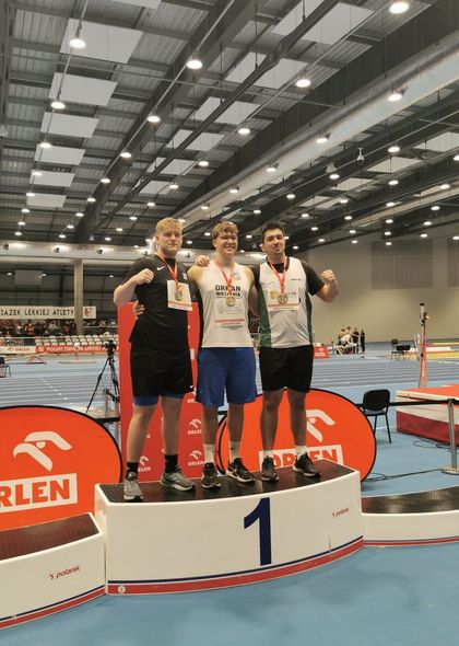 Mężczyźni stojący na podium na hali sportowej