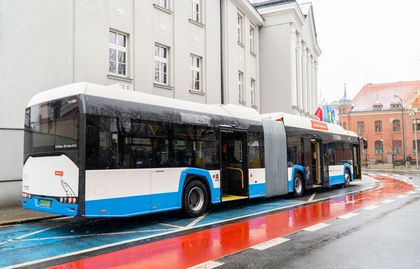 Miejski autobus przegubowy stojący przez UM