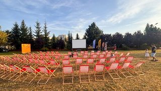 Kino plenerowe, na którym są rozstawione leżaki i widać w tle ekran. 