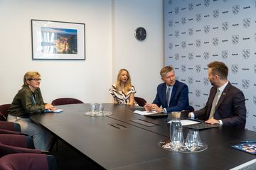 Zdjęcie przedstawia dwie kobiety i dwóch mężczyzn siedzących przy biurku.