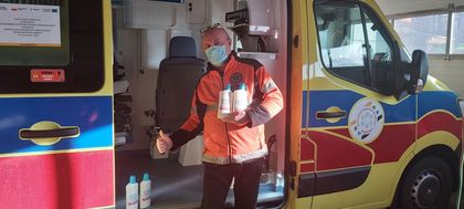 Ratownik medyczny stojący przed otwartą karetką