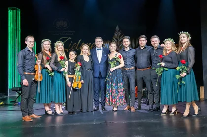 Grupa muzyków pozuje do zdjęcia z instrumentami.