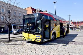Żółty autobus miejski stojący na przystanku
