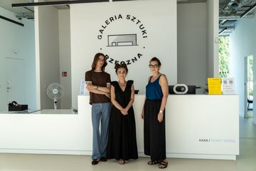 Zdjęcie przedstawia trójkę osób pozujących do zdjęcia w Galerii Sztuki. 