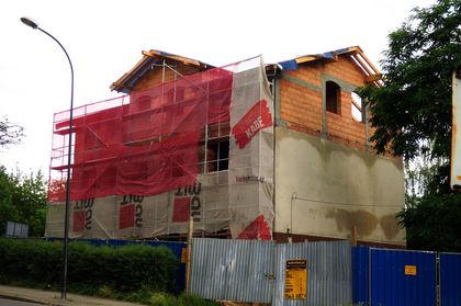 Dom samotnej matki fot.L.Tyl 4 Ceglany budynek w trakcie modernizacji. Widoczne rusztowania. W tle zieleń.