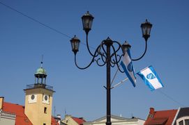 Wieża ratusza i stylowa latarnia, na której powiewają flagi Rybnika. 