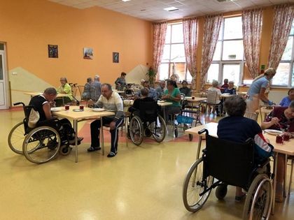 Jadalnia Miejskiego Domu Pomocy Społecznej, pensjonariusze siedzą przy stole. 