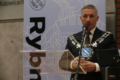 Mężczyzna przemawiający do mikrofonu. 