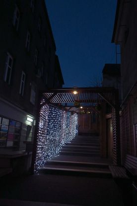 Świecące o zmierzchu świąteczne dekoracje miasta - choinka, karuzela, girlandy nad ulicą