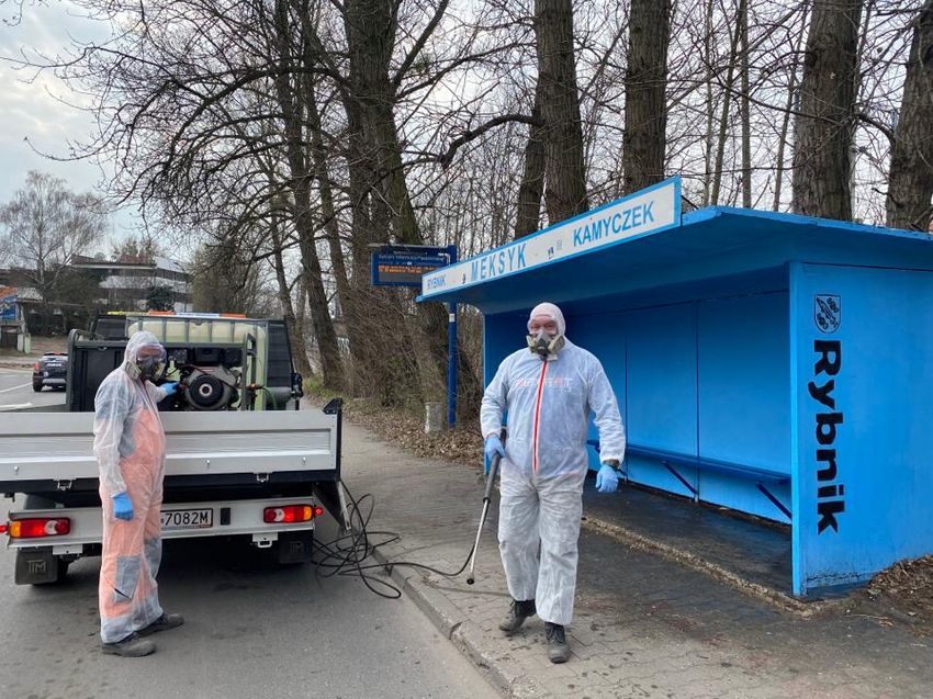 Pracownicy służb komunalnych dezynfekują wiatę przystankową