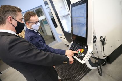Dwóch mężczyzn testujących sprzęt elektroniczny w nowocześnie wyposażonej pracowni kształcenia zawodowego 
