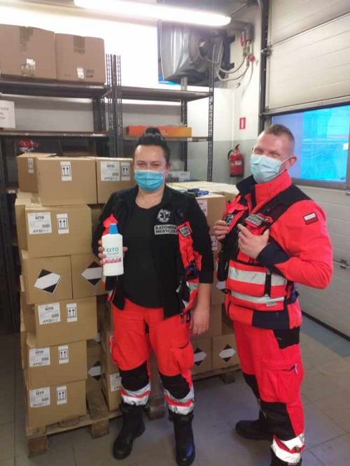 Dwoje ratowników medycznych na tle stosu tekturowych pudeł